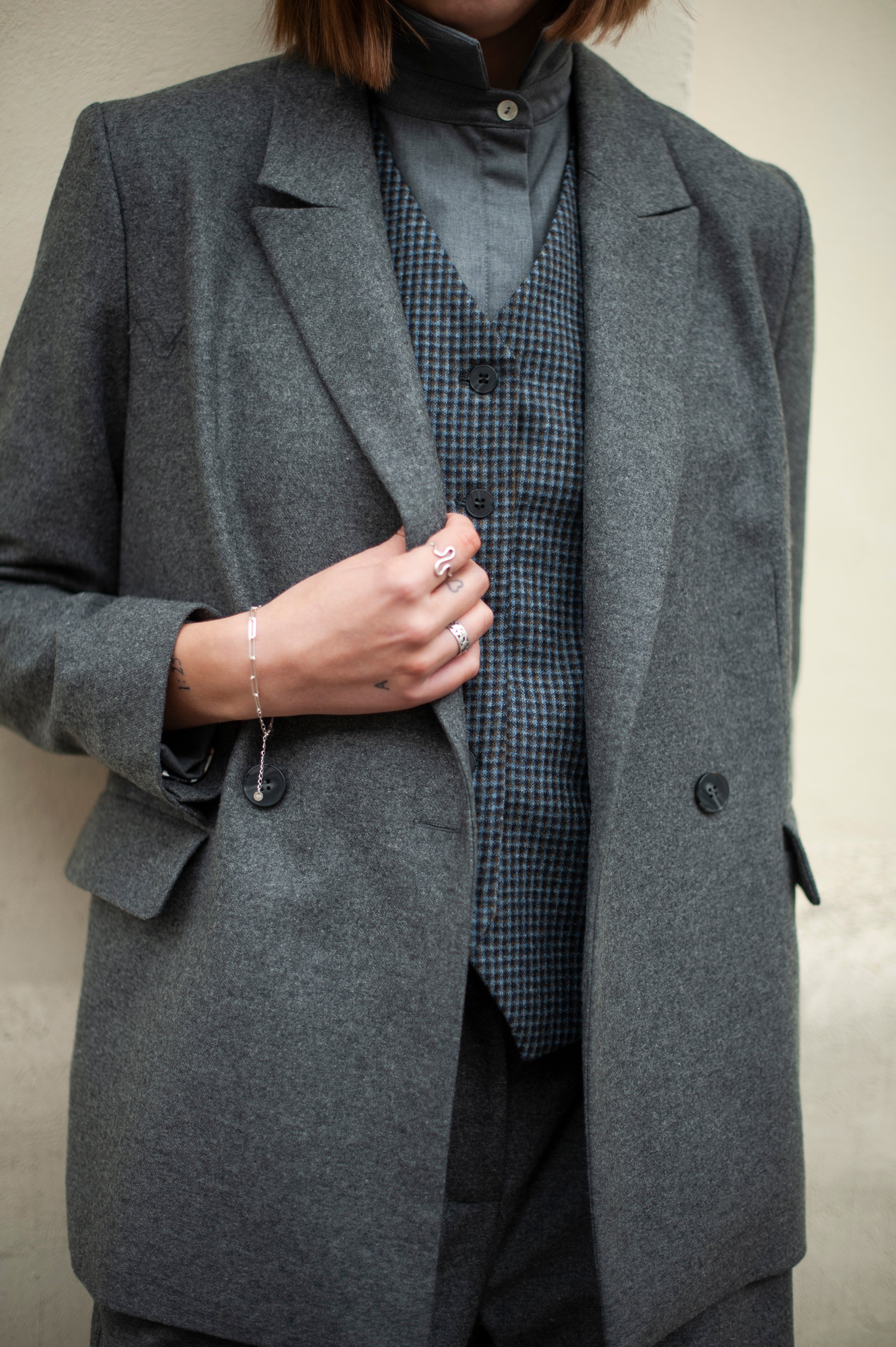 A duo of a blue checked suit vest and a grey double-breasted blazer. Handmade capsule collection for women.