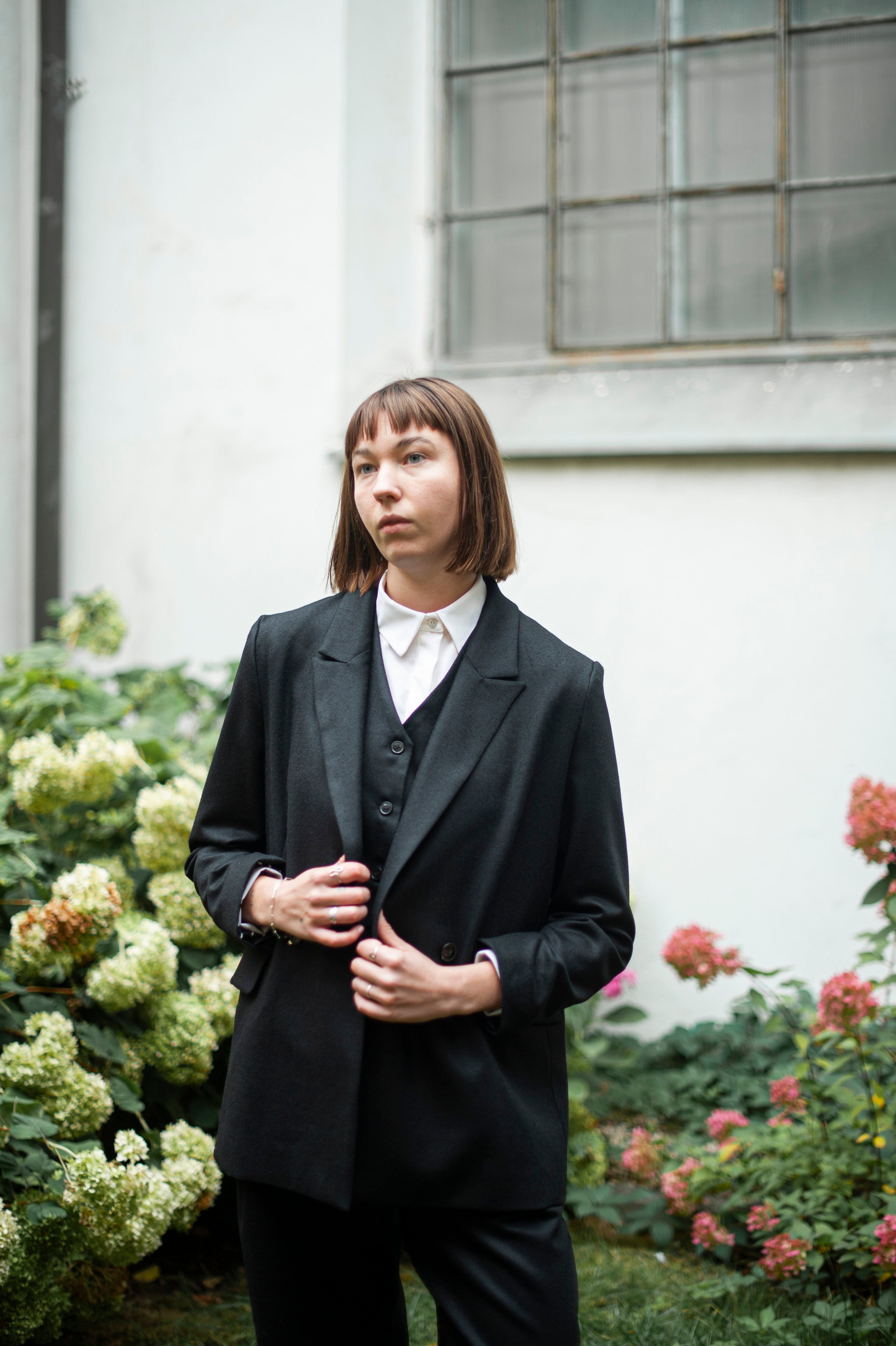 Black peak lapel blazer and a matching suit vest layered with a white merino wool shirt
