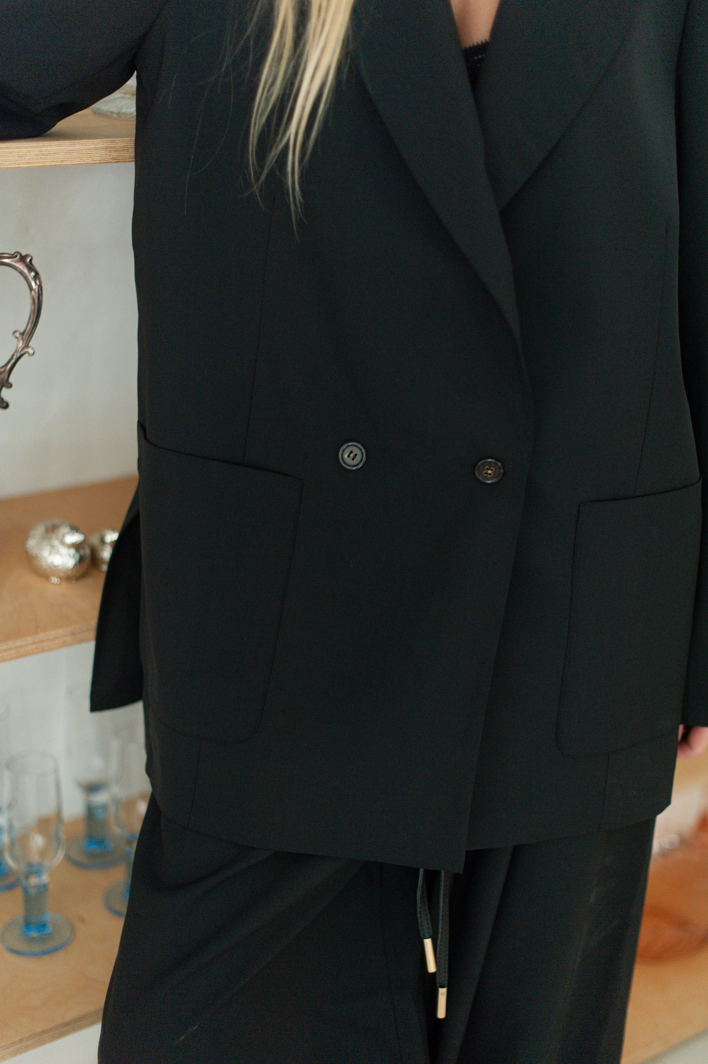 Close-up of wool blazer showing the front pockets and the double-breasted closure.