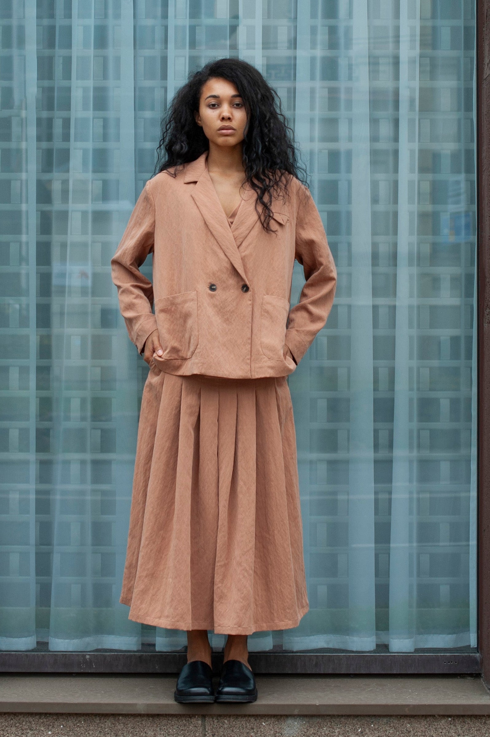 Women's boxy blazer in light beige linen. The blazer is paired with a matching color palazzo pants with chunky pleats.