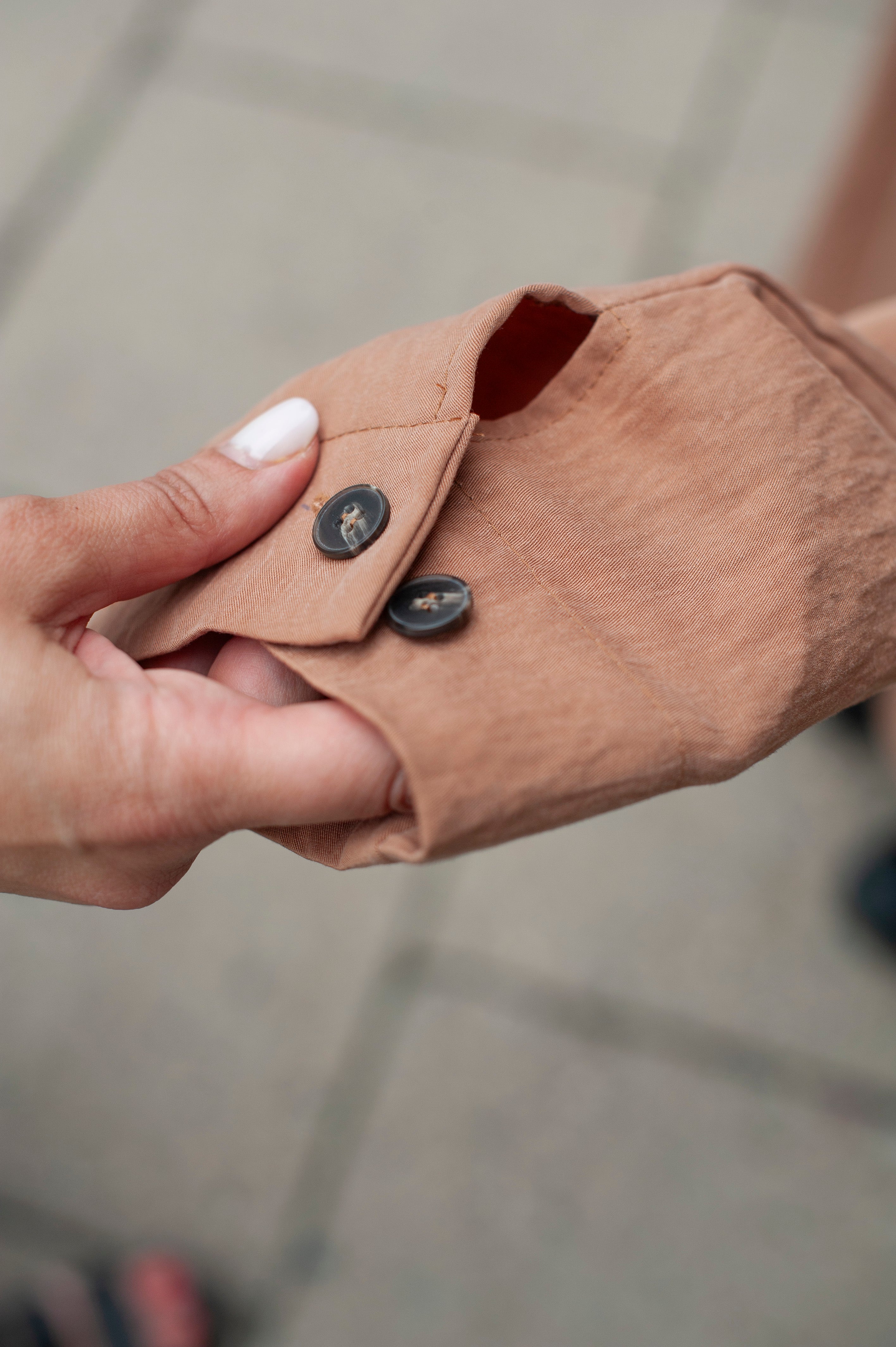 A buttoned cuff of a linen jacket