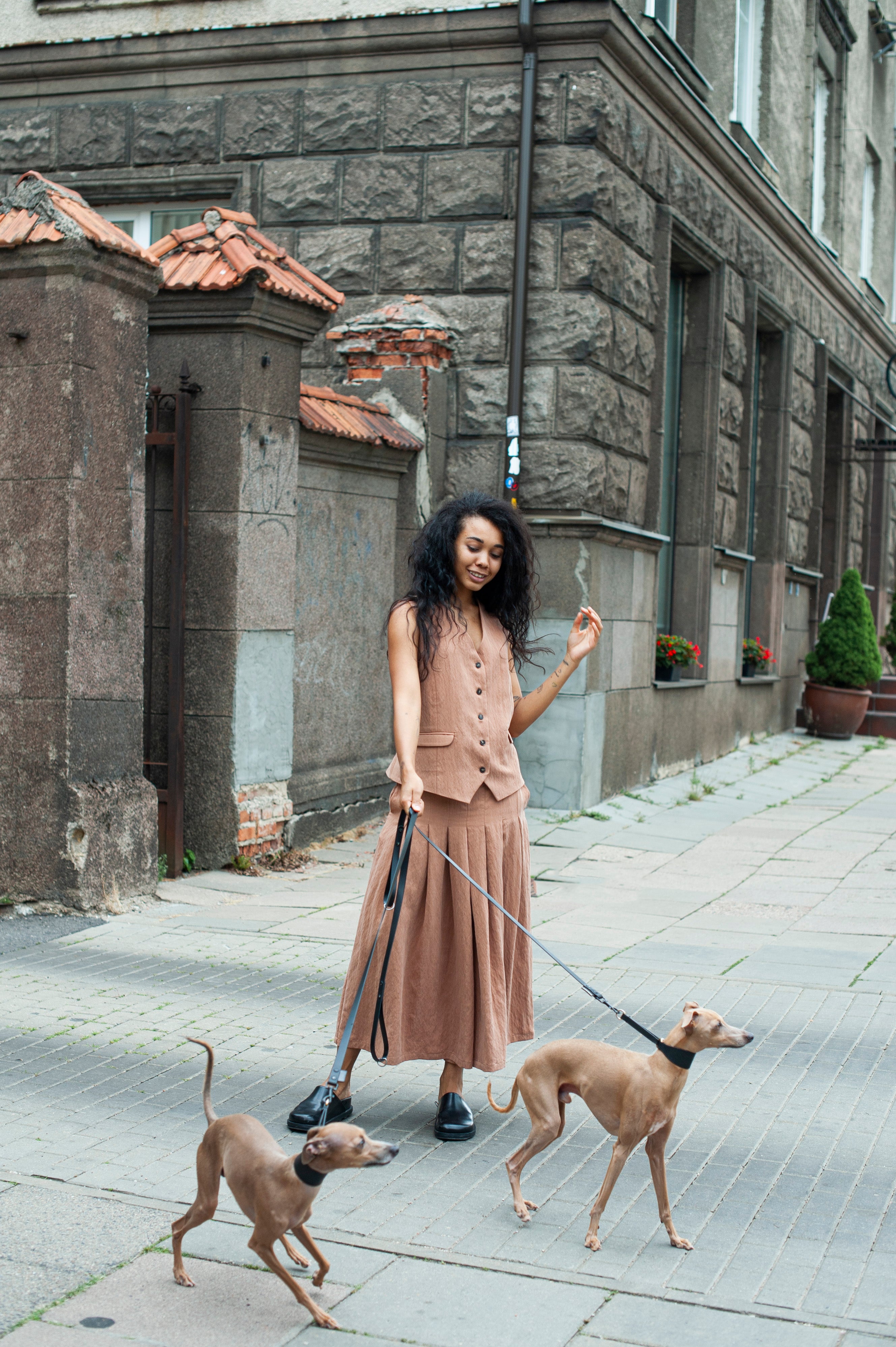 A girl wearing a light beige linen vest and pleated wide-leg pants