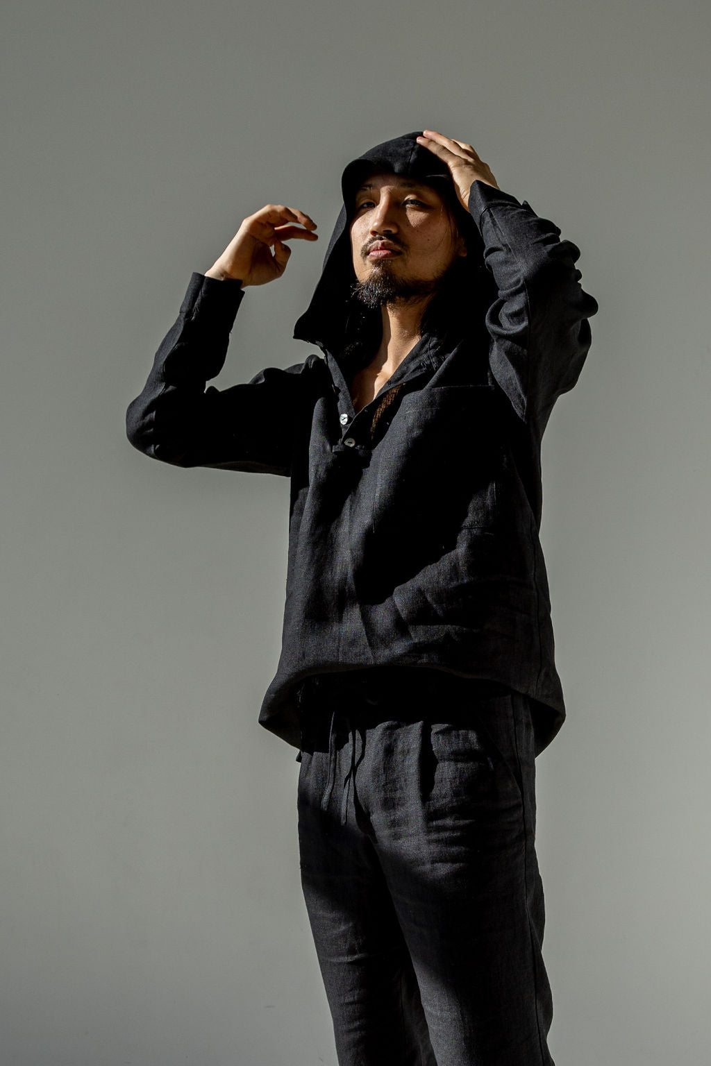 Lightweight linen hoodie with adjustable sleeves and top button closured.