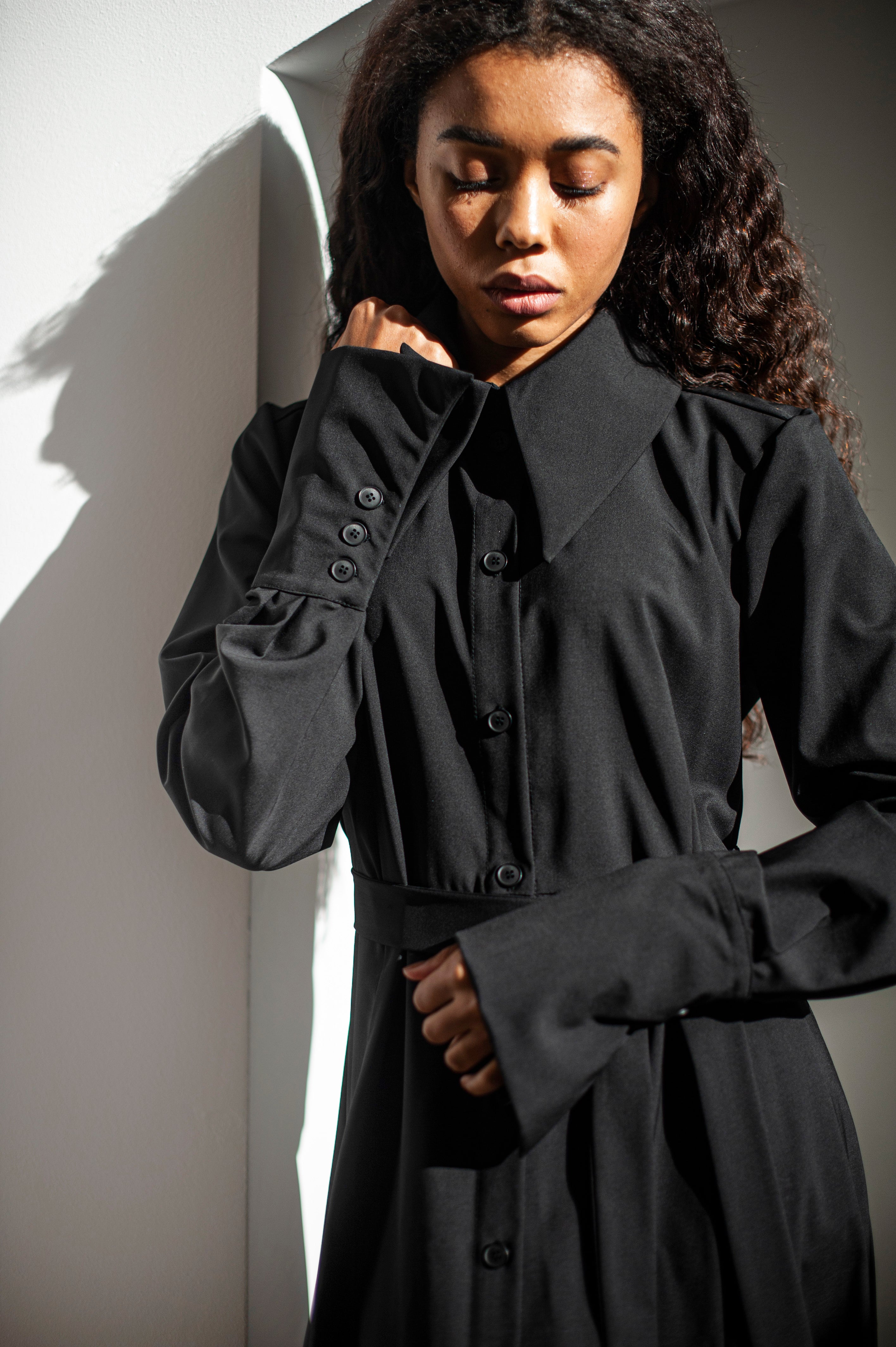 Black elegant dress with a button-up closure and collar. Made of 100% merino wool.