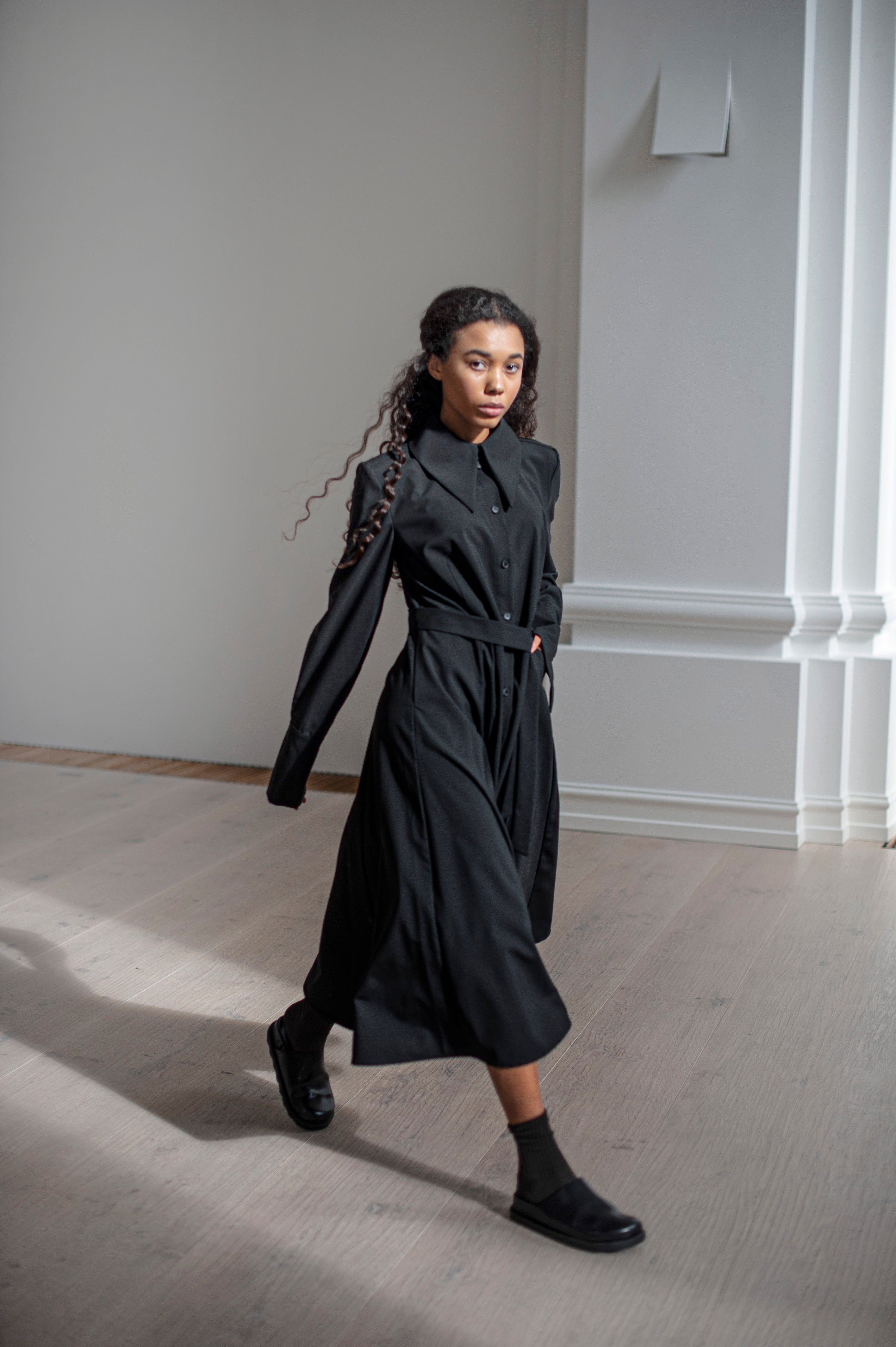 Black hand-crafted Merino wool dress in an A-line silhouetted and a belt.  The dress also features French cuffs adding an extra dose of class and elegance.