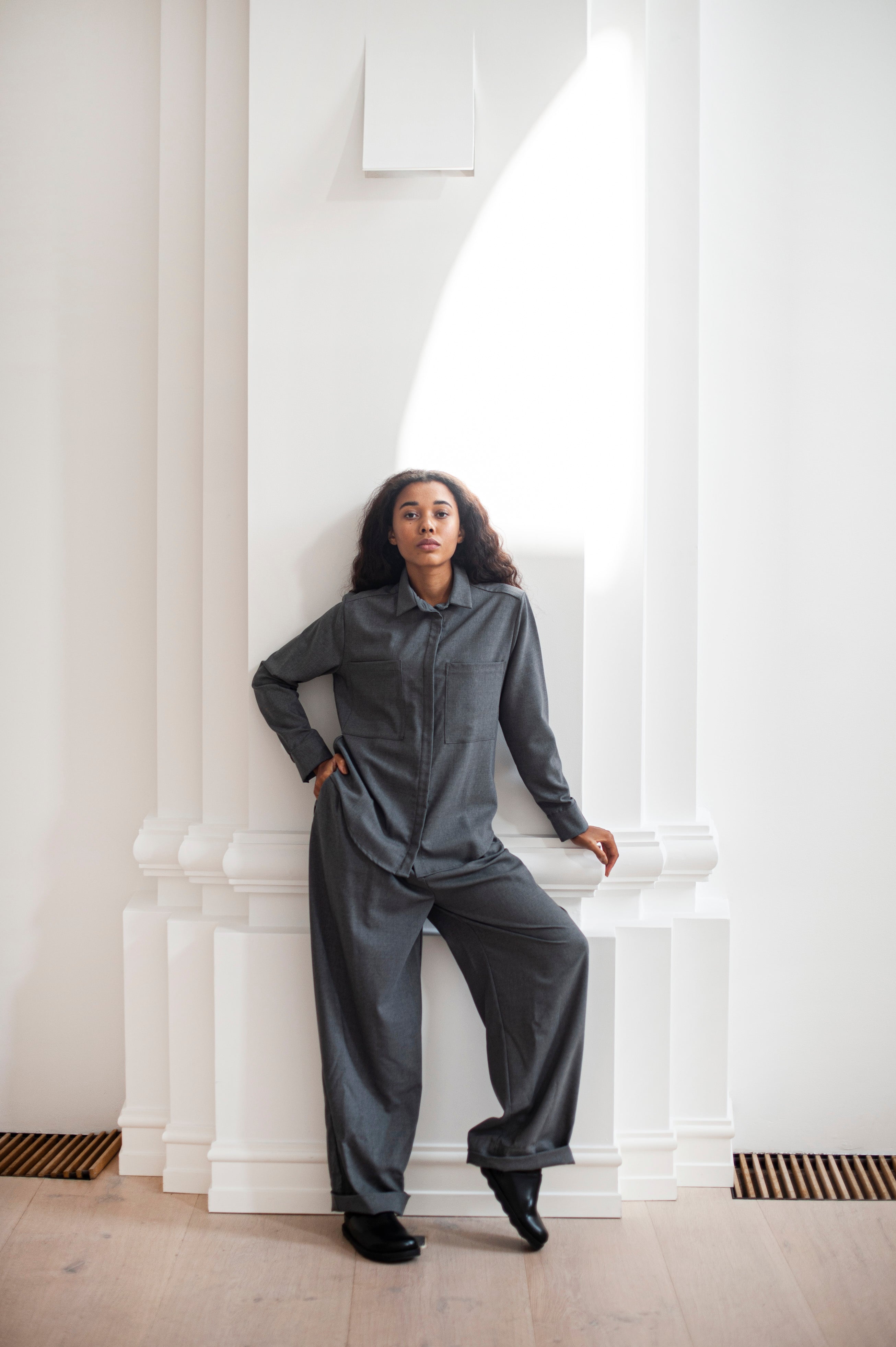 Women's grey Merino wool shirt with a collar and two functional pockets on the chest. The shirt is paired with a matching wide leg trousers