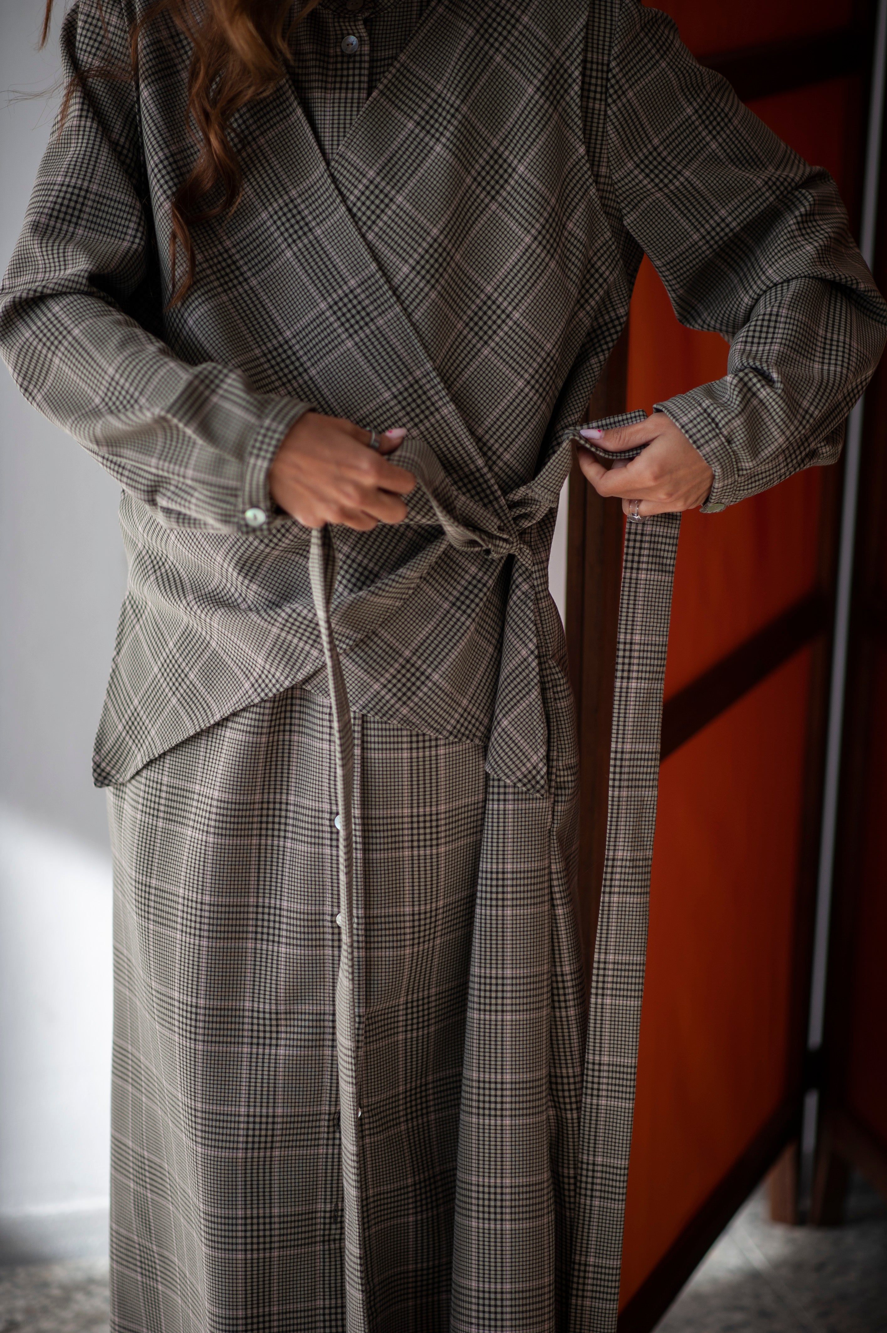 A button-up A-shape wool dress with extra wrap construction in the front.