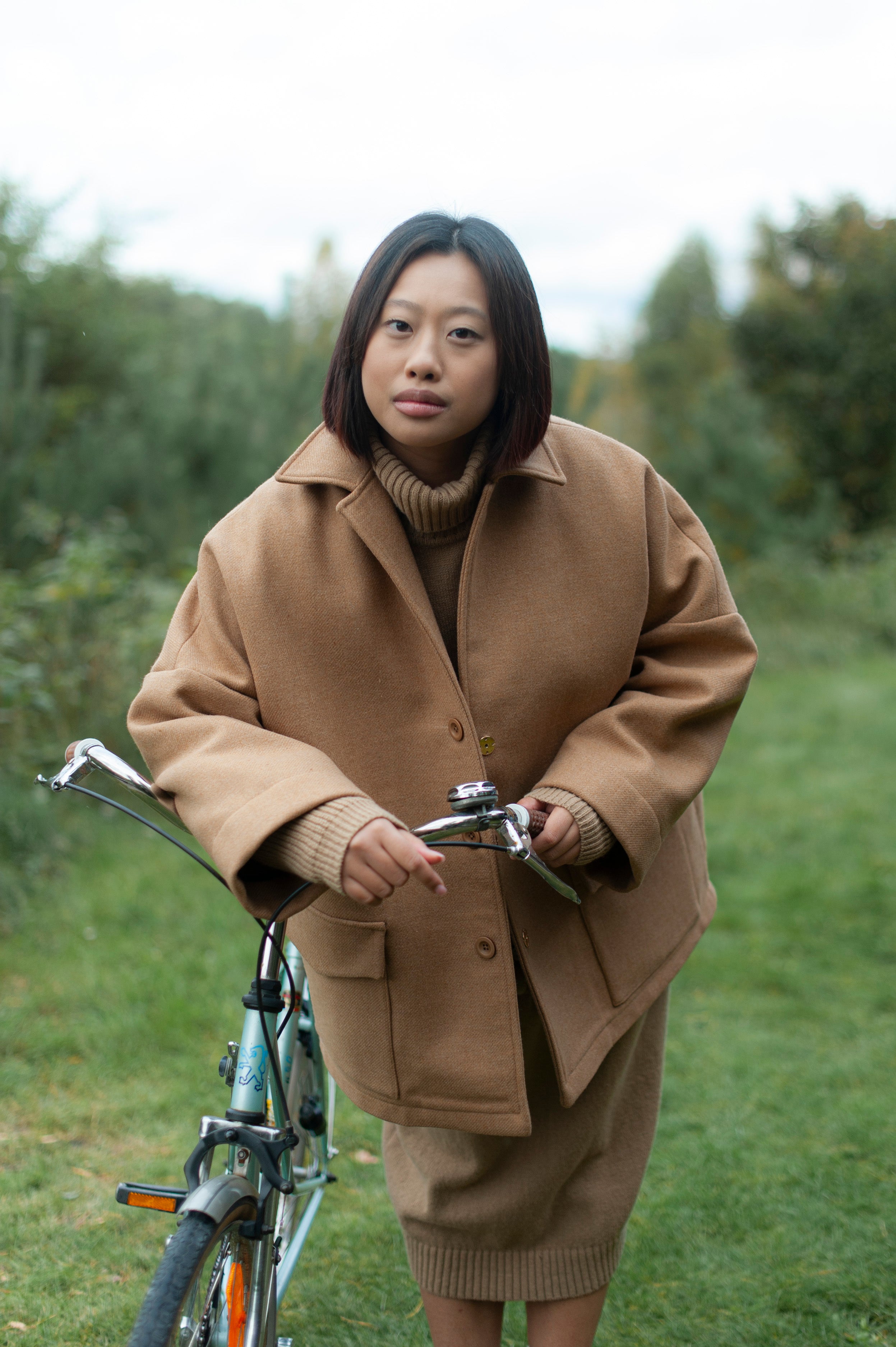 Camel color oversized one-size jacket made of double-cloth high quality wool. The jacket boasts a lapel color, dropped shoulders, wide sleeves and two spacious patch pockets with flaps.