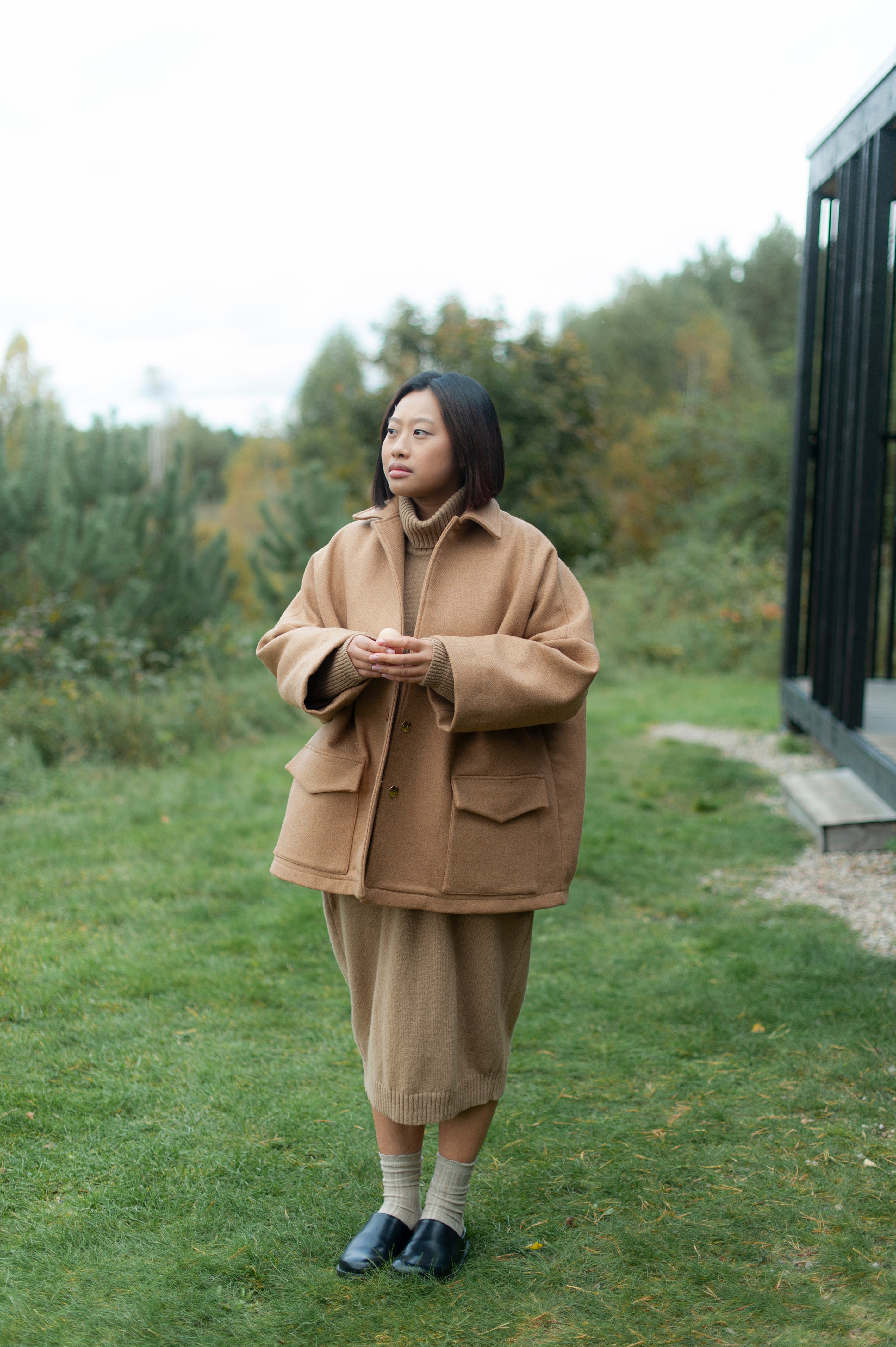 Camel color oversized one-size jacket made of double-cloth high quality wool. The jacket boasts a lapel color, dropped shoulders, wide sleeves and two spacious patch pockets with flaps.