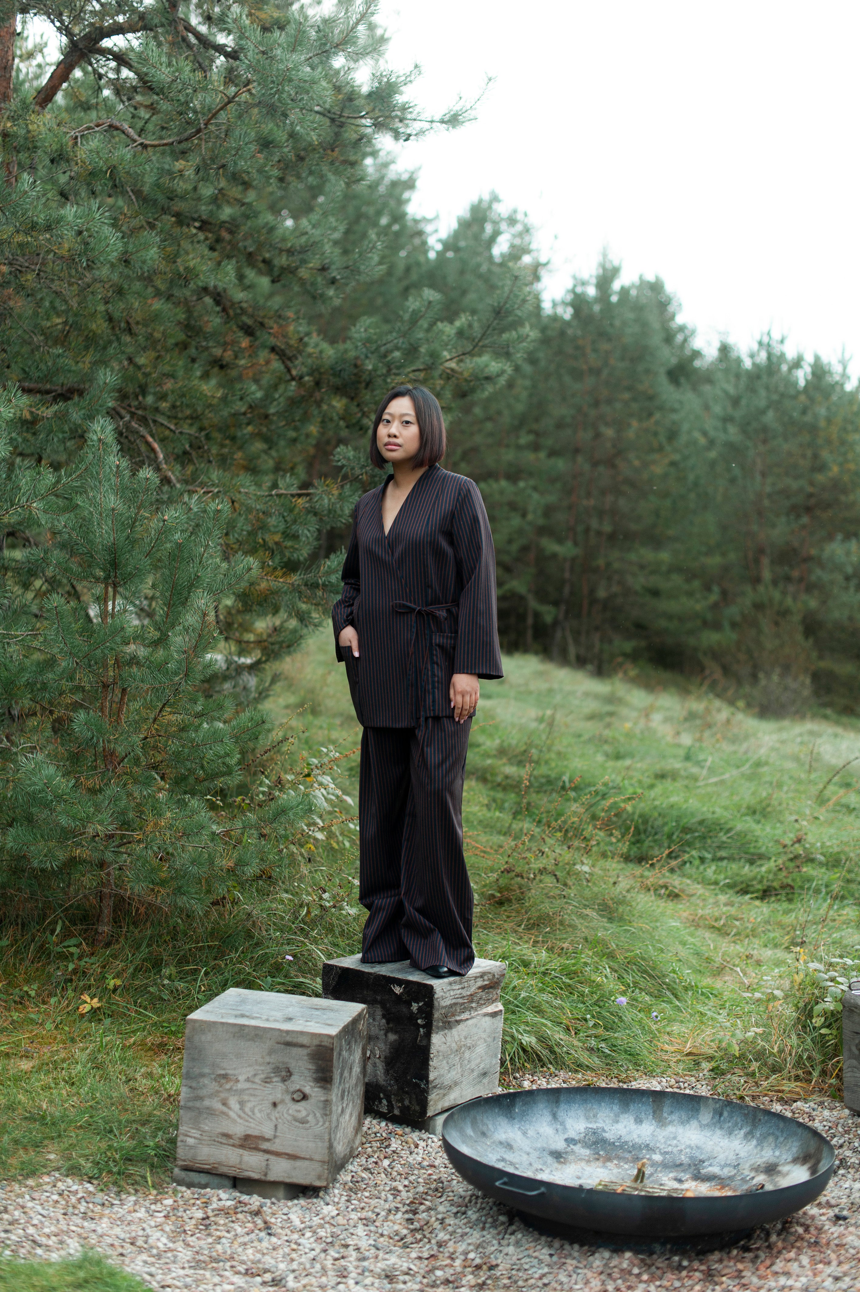 Long striped pleated wide-leg pants with a zipper closure and adjustable elasticated waistband. The pants are paired with a V-neck wrap top