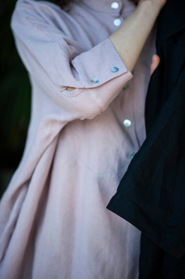Buttoned cuffs of a linen tunic dress with a partial button closure.