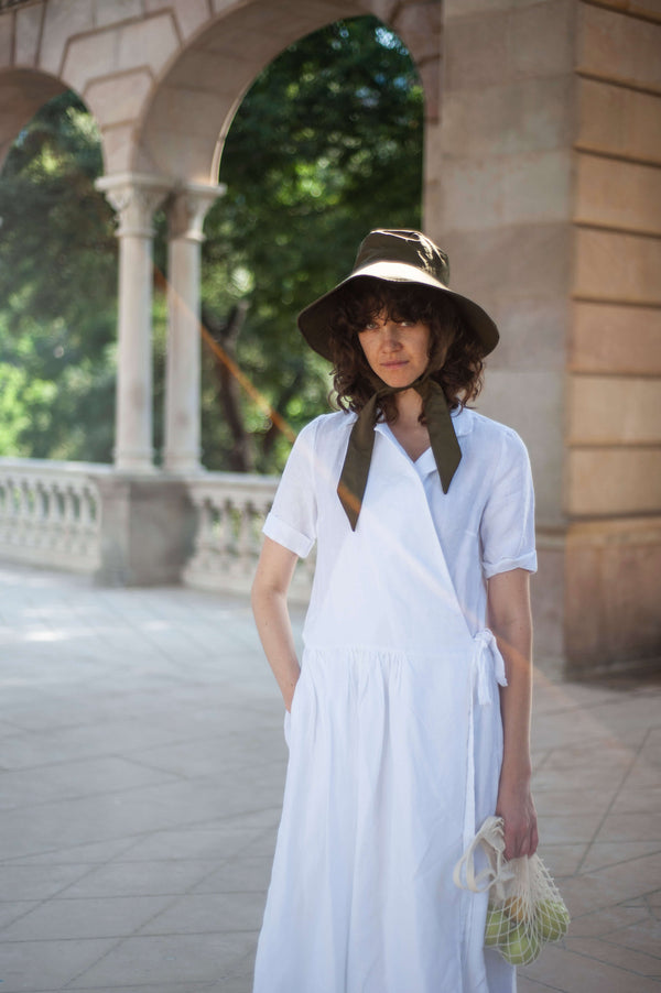 White wrap dress with a lapel collar and short sleeves. Minimalist linen piece to elevate your casual style.