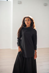 A duo of a black wool blouse with a high neck boasting wide foldback cuffs. Paired up with a matching A-line silhouette skirt boasting an elasticated waistband.