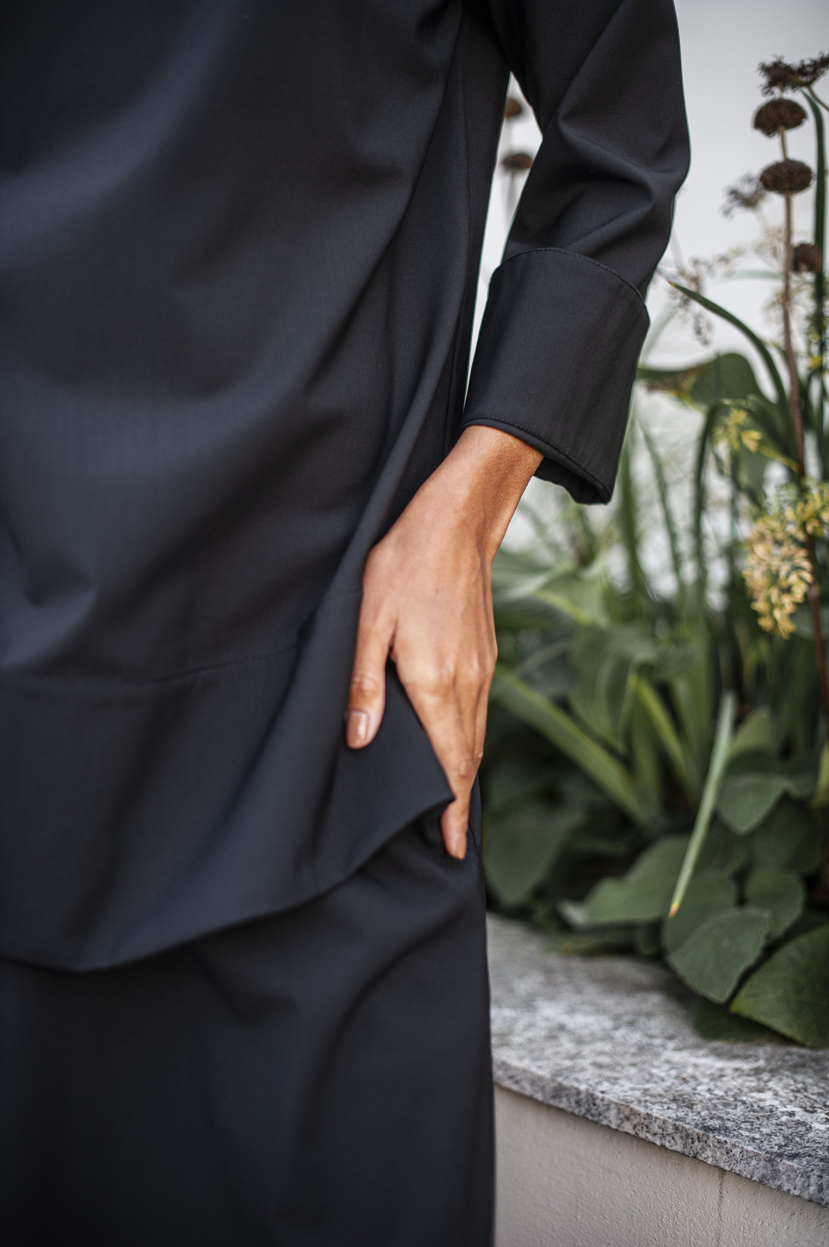 Foldback cuffs of a black wool top. Feel classic and chic in this high-quality wool top that will last for years.