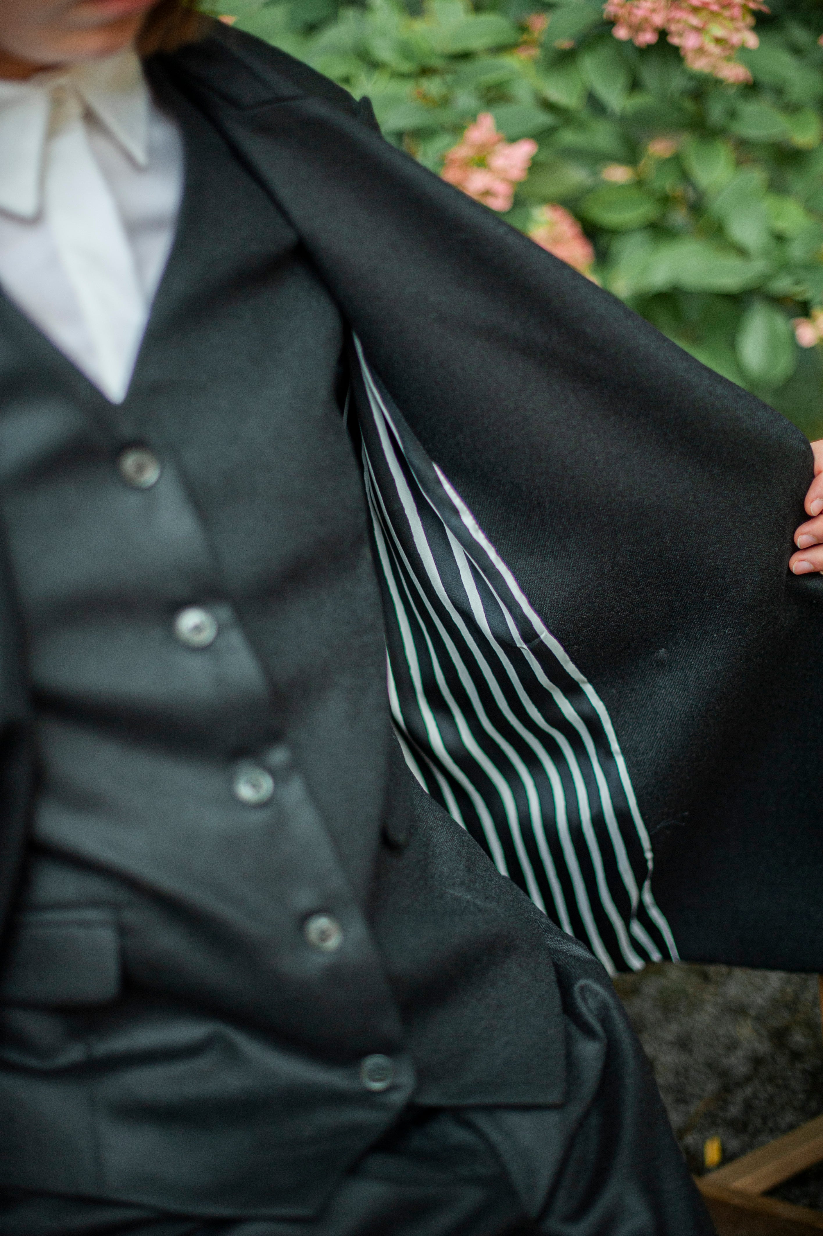 Black tweed wool blazer with a striped quality lining. The blazer is paired with a matching waistcoat. Women's three-piece suit