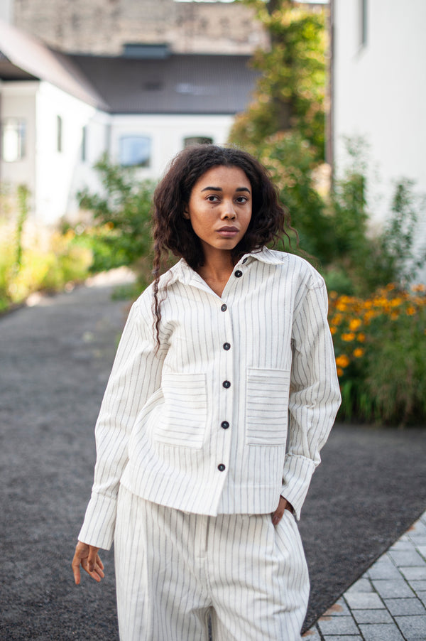 Women's one-size cotton jacket made of organic cotton. White pinstripe fabric, elegant cuffs and two spacious front pockets