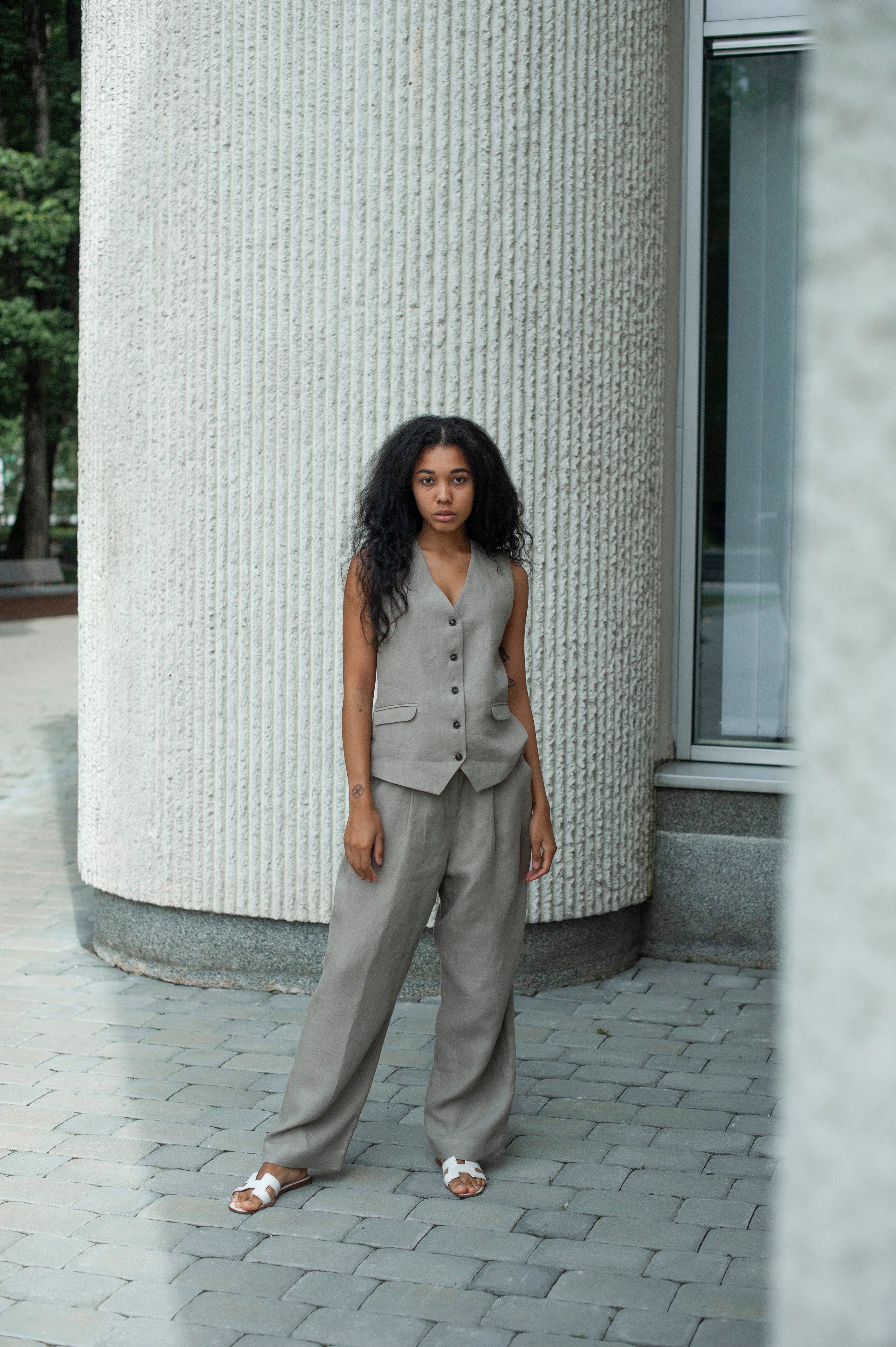 Elegant linen vest in light grey. The girl is also wearing straight wide-leg linen pants.