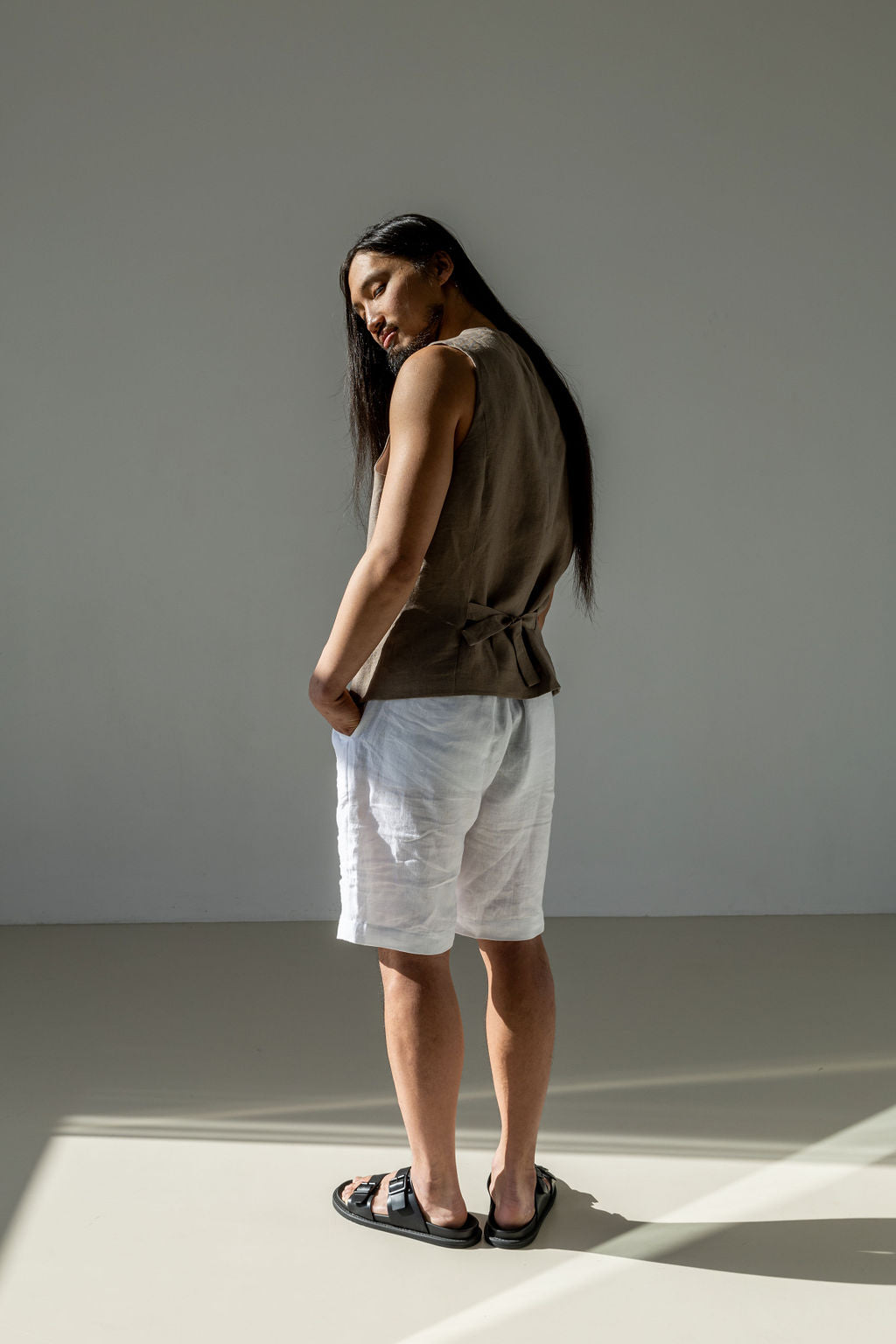 White linen shorts for men. Classic cinched linen suit vest in beige.