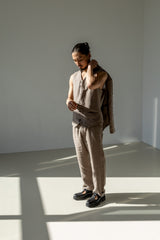 Three-piece linen suit for men in beige. Minimalist, relaxed-fitting tapered leg pants, linen waistcoat, and a blazer.