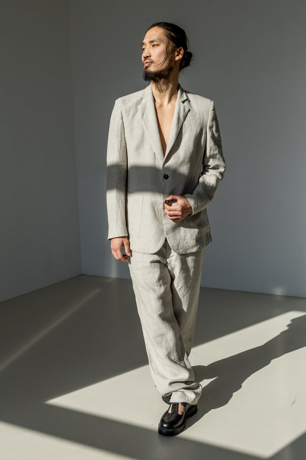 Men's natural linen grey blazer with a two-button closure paired with matching classic linen pants