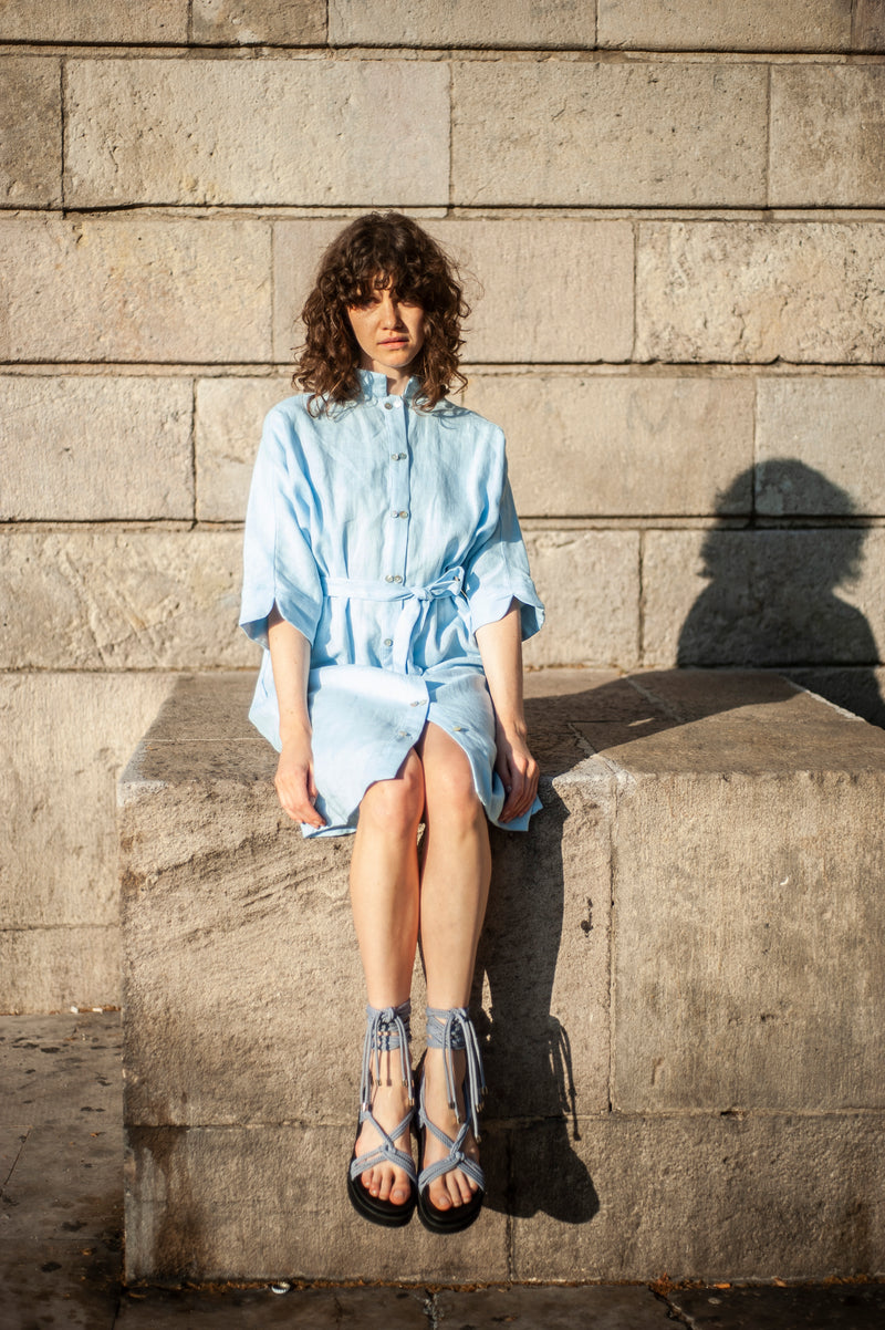 Light blue linen dress with two-layer buttons in the front, subtle sleeve ends and a stand-up collar