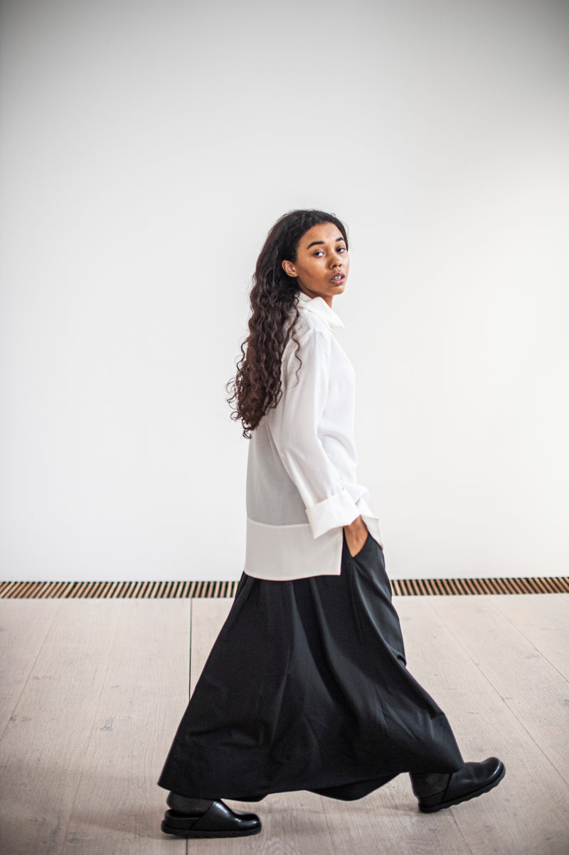 Black wool skirt paired with a white loose-fitting top