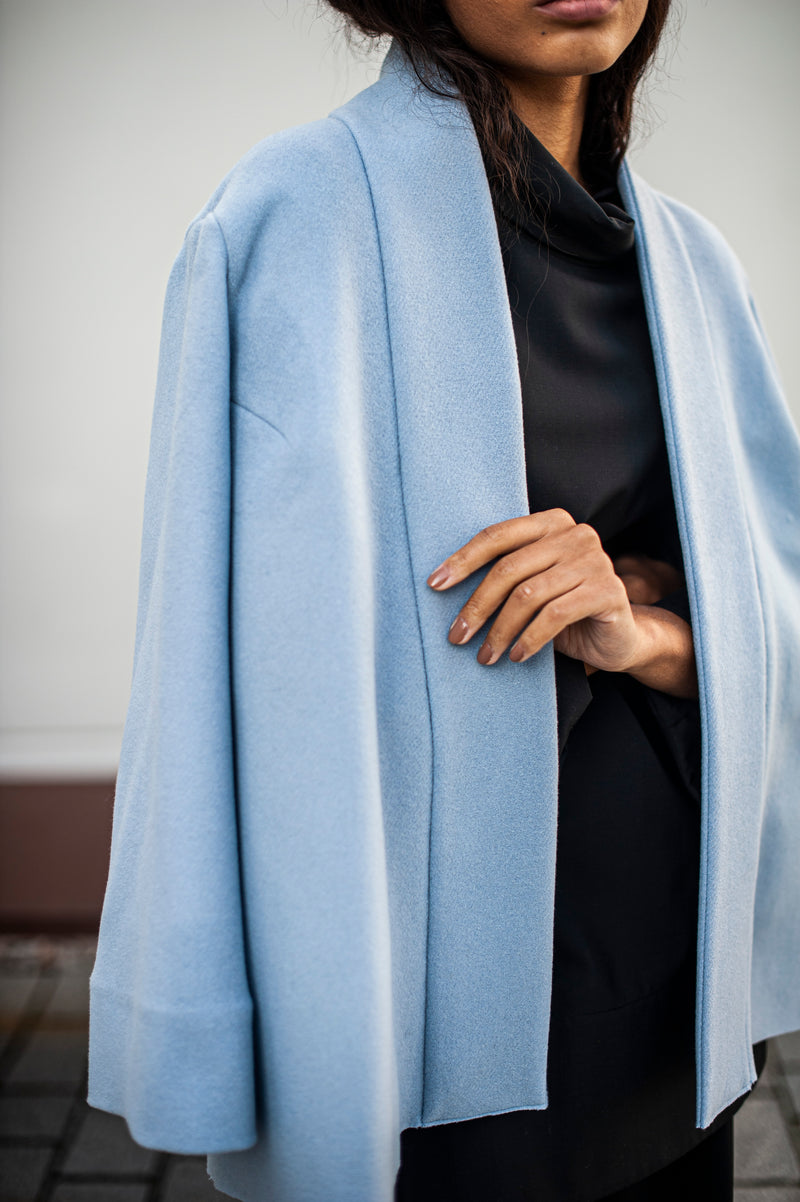 Baby blue wool jacket with a clean line collar and wide sleeves. Paired with a monochrome outfit.