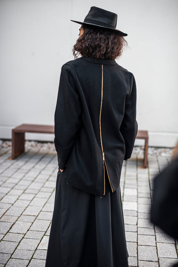 Black wool blazer with a longer rounded back featuring a functional zipper