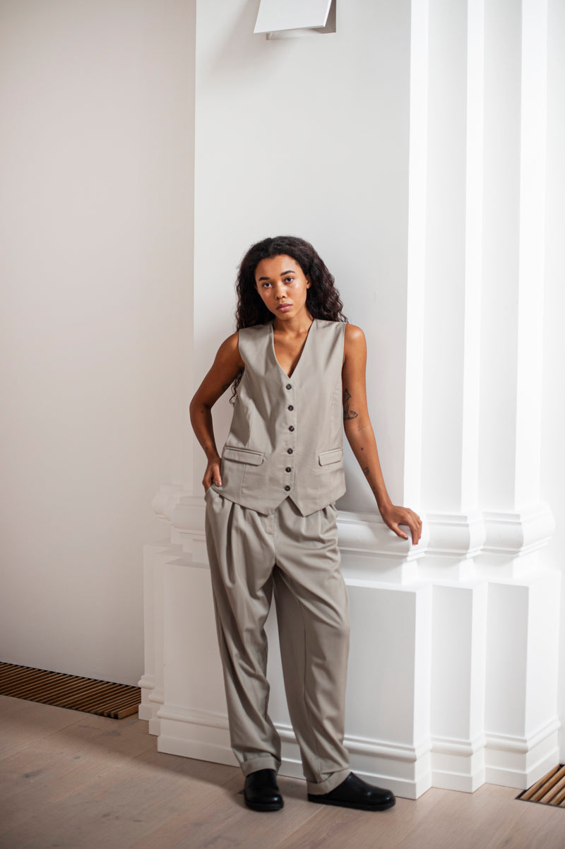 An ensemble of a waistcoat and loose-fit banana trousers with minimalist pleats.