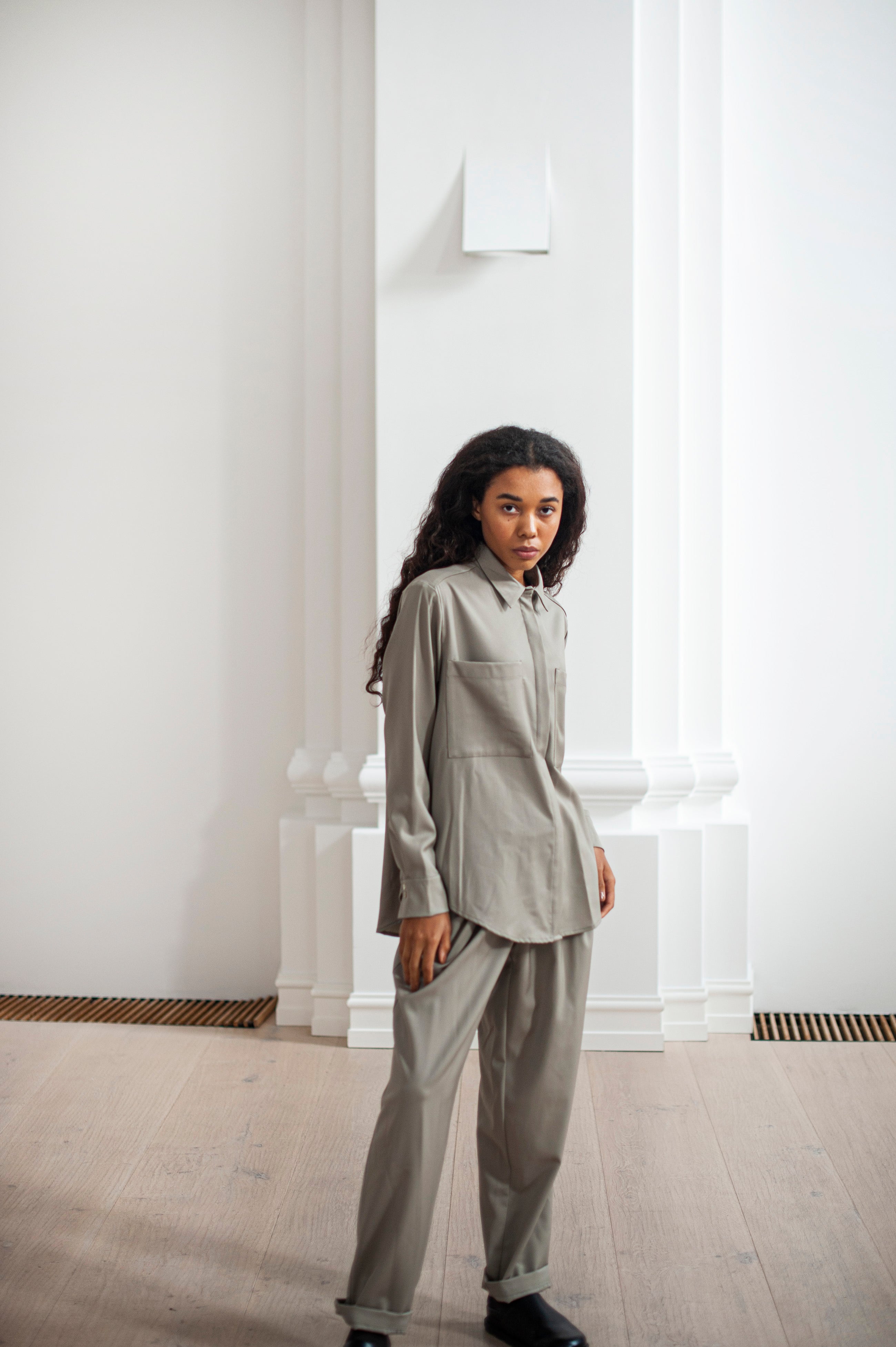 Women's button-up wool shirt with a collar, back pleat, and two front pockets.