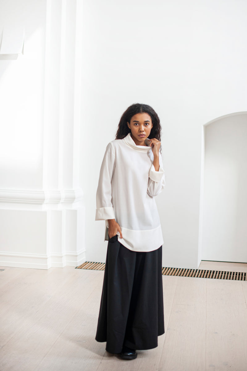 A duo of a white high-neck blouse and a wide A-line silhouette. Timeless pieces for your classic wardrobe.