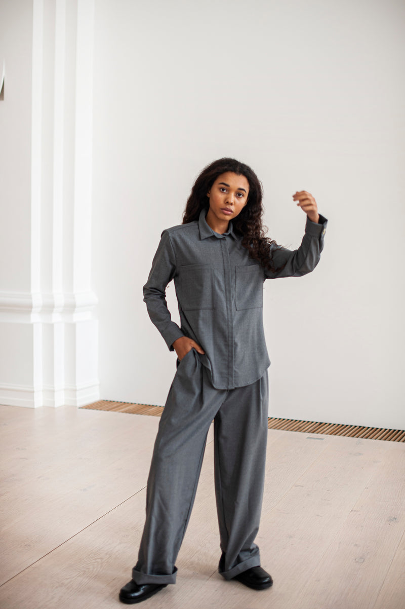 A monochrome outfit of a loose-fit wool shirt and wide leg pleated trousers