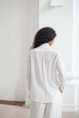 Women's white button-up shirt shown from the back. The back features an inverted  pleat.
