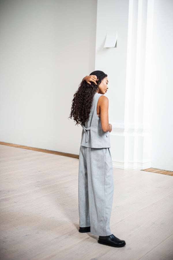 Wide-leg heavy cotton trousers in grey paired with a matching cinched waiscoat