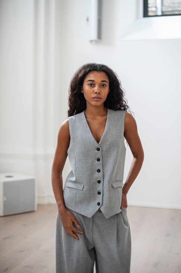 Heavy-weight cotton waistcoat in grey. Classic silhouette, welt pockets and cinched back