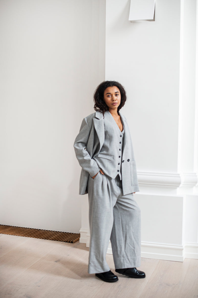 Three-piece suit of a blazer, waistcoat, and wide-leg trousers. Ethically made of heavy cotton. Grey color for every day and special occasions.