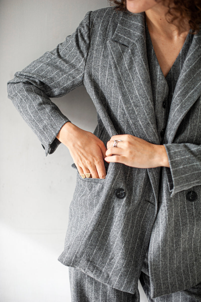 Grey striped blazer with a double-breasted closure.