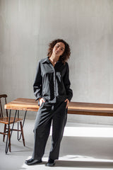 A black ensemble of a loose wool shirt and wide-leg trousers.