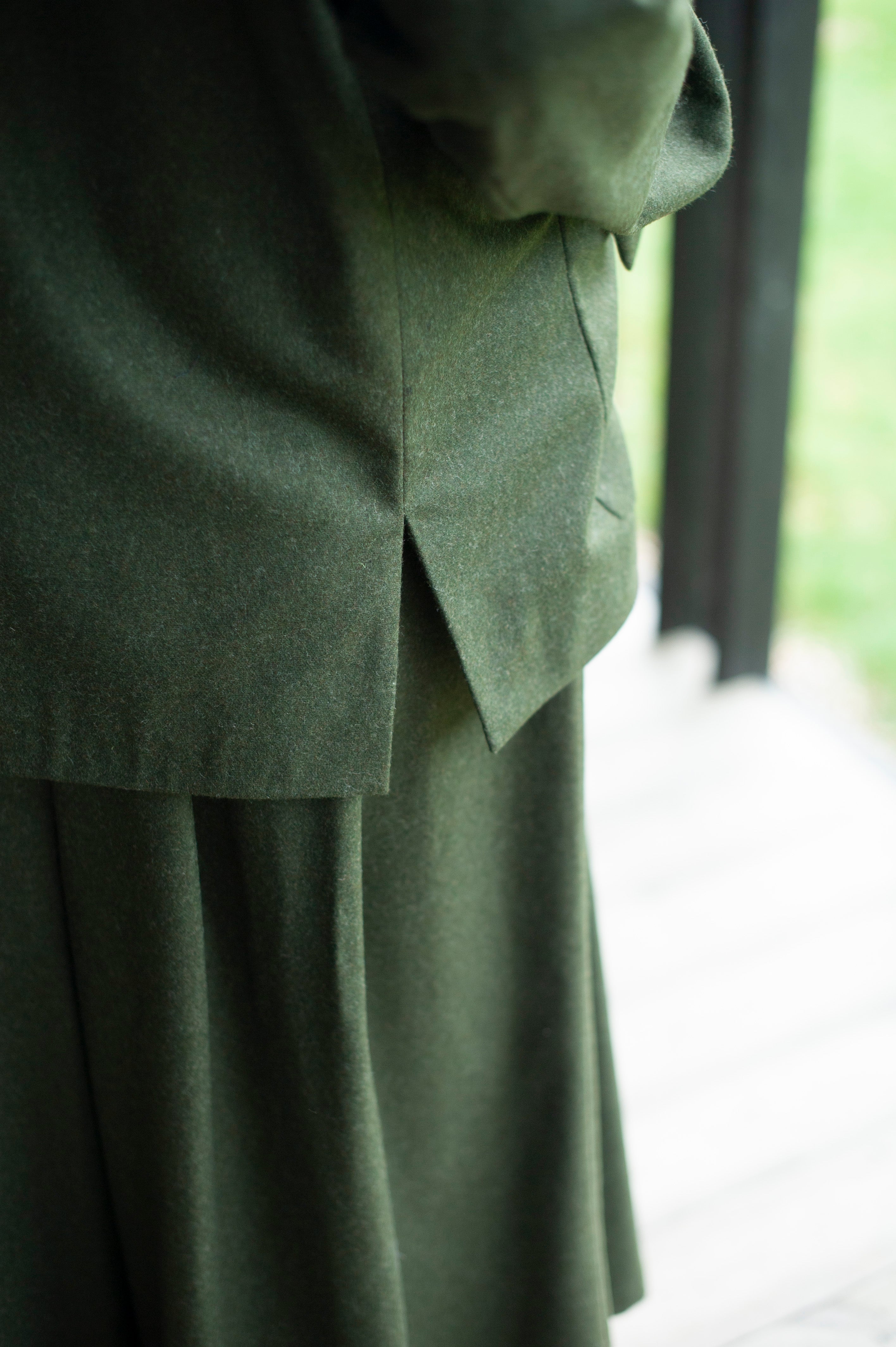 The side slits for a green wool blend blazer in green